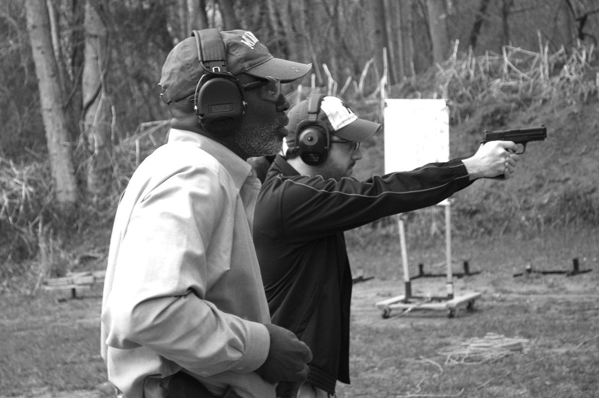 Two men on a gun range participating in handgun safety training.